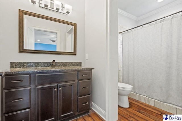 bathroom with wood-type flooring, vanity, crown molding, and toilet