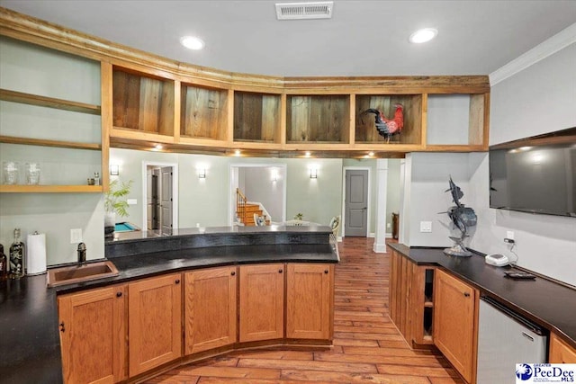 kitchen with ornamental molding, sink, stainless steel fridge, and light wood-type flooring