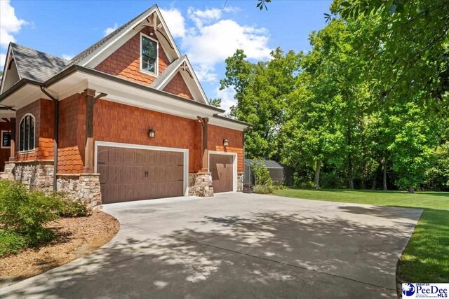 view of side of home featuring a garage and a yard