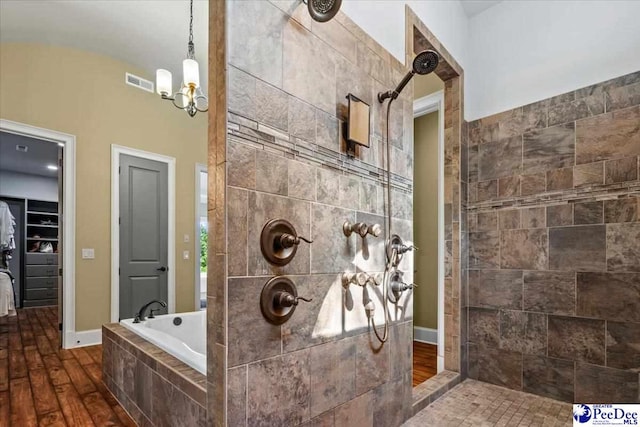 bathroom with an inviting chandelier, hardwood / wood-style floors, and separate shower and tub