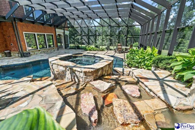 view of swimming pool featuring a lanai, a patio area, and an in ground hot tub