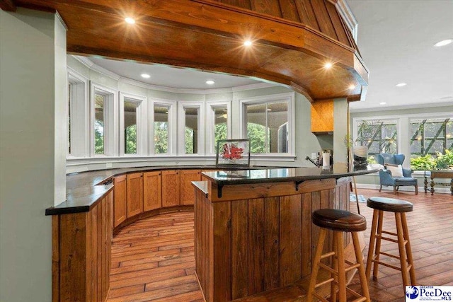 bar with crown molding and light hardwood / wood-style floors