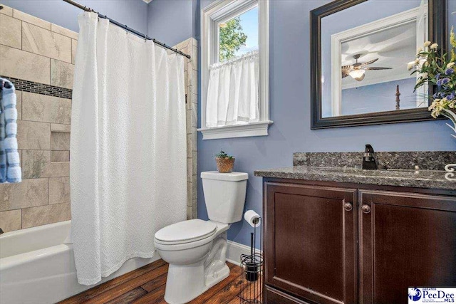 full bathroom featuring vanity, hardwood / wood-style floors, shower / bath combo with shower curtain, and toilet