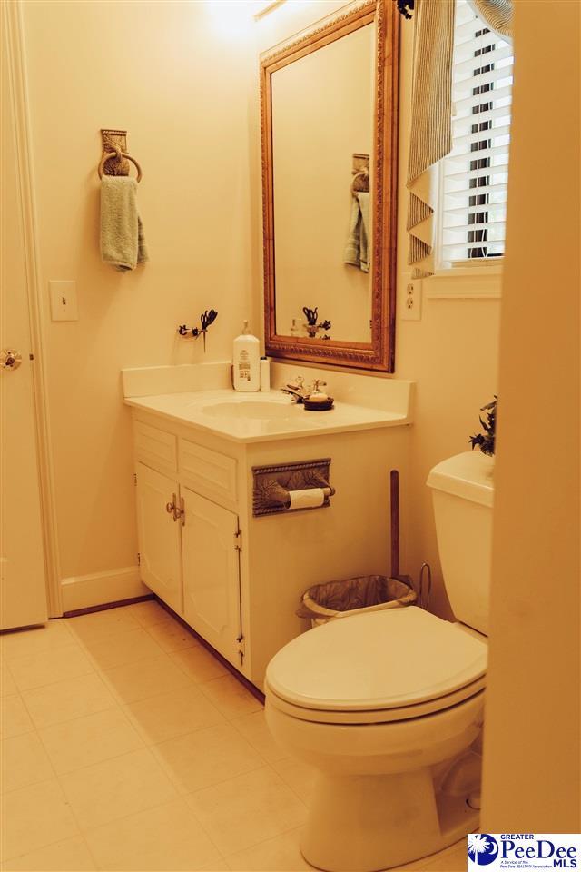 bathroom with tile patterned flooring, toilet, and vanity