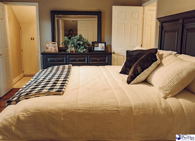 bedroom with baseboards and wood finished floors