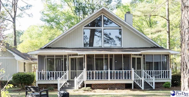 rear view of house featuring a sunroom and a chimney