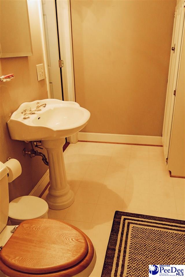 half bath with baseboards and toilet