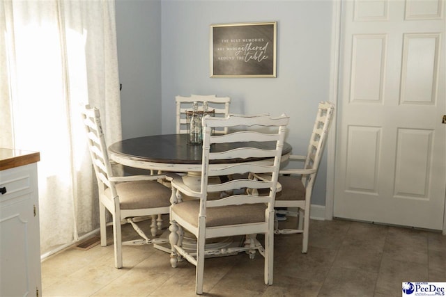 dining area featuring baseboards and light tile patterned flooring