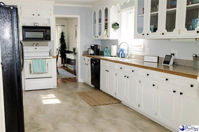 kitchen with white cabinets, ornamental molding, a sink, black appliances, and glass insert cabinets