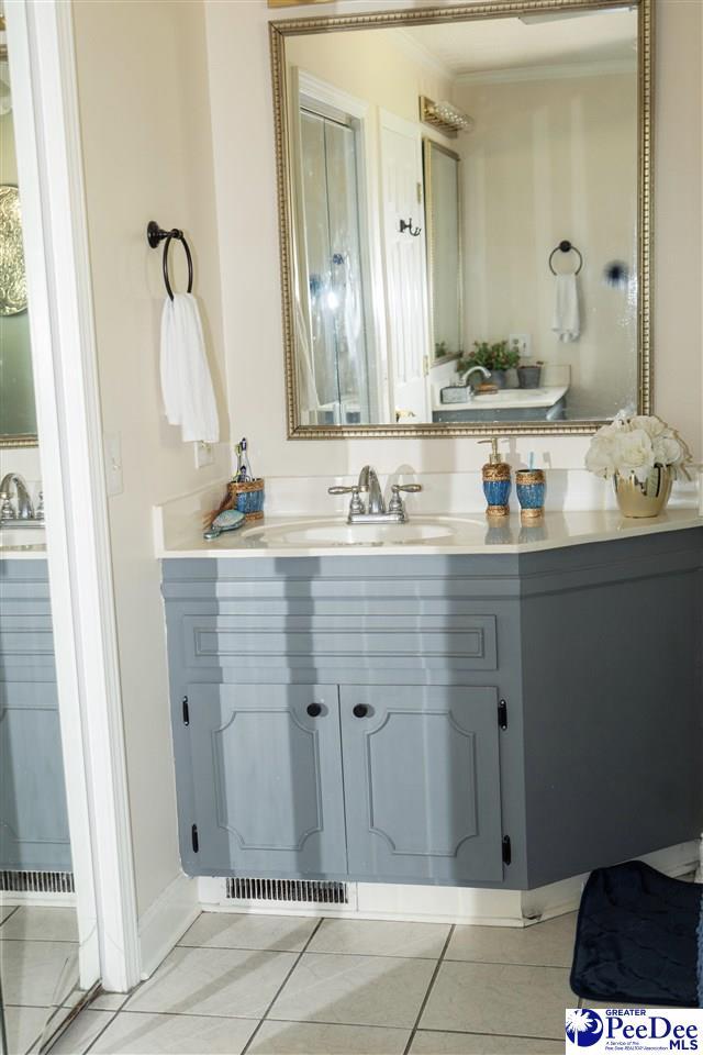 bathroom with tile patterned floors, vanity, and crown molding