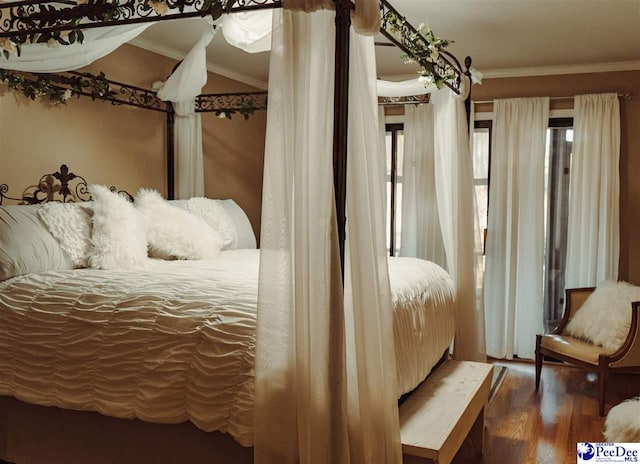 bedroom featuring wood finished floors and ornamental molding