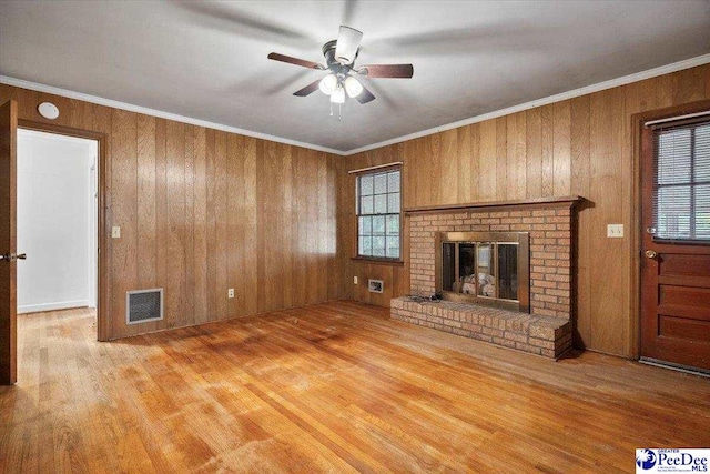 1817 E Sandhurst Dr, Florence, SC 29505 - unfurnished living room featuring wood finished floors, a ceiling fan, a brick fireplace, and wood walls