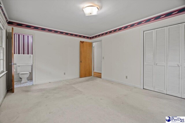 1817 E Sandhurst Dr, Florence, SC 29505 - unfurnished bedroom featuring a closet, ensuite bath, carpet, baseboards, and ornamental molding