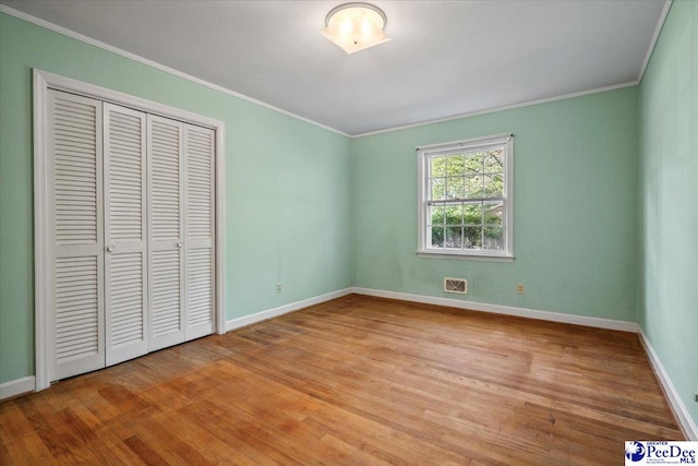 1817 E Sandhurst Dr, Florence, SC 29505 - unfurnished bedroom featuring wood finished floors, baseboards, crown molding, and a closet