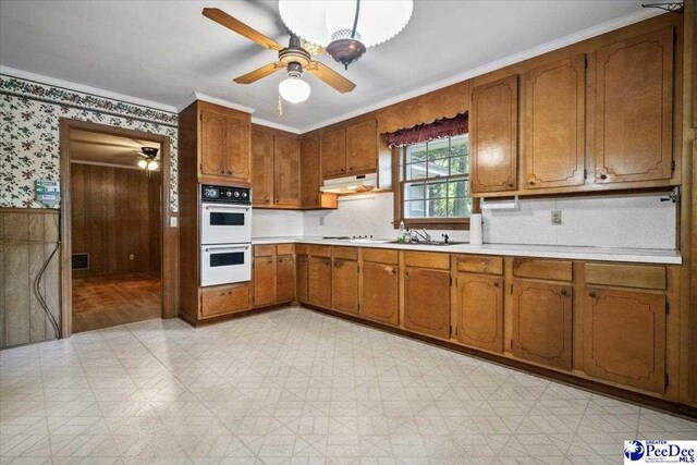 1817 E Sandhurst Dr, Florence, SC 29505 - kitchen with double oven, light floors, brown cabinetry, wallpapered walls, and ornamental molding