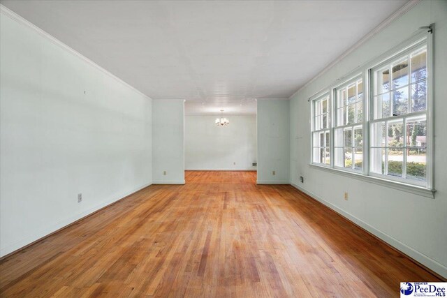 1817 E Sandhurst Dr, Florence, SC 29505 - unfurnished room featuring a chandelier, light wood-style flooring, crown molding, and baseboards