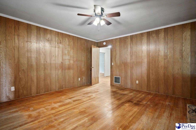 1817 E Sandhurst Dr, Florence, SC 29505 - empty room featuring wood finished floors, ceiling fan, and wood walls