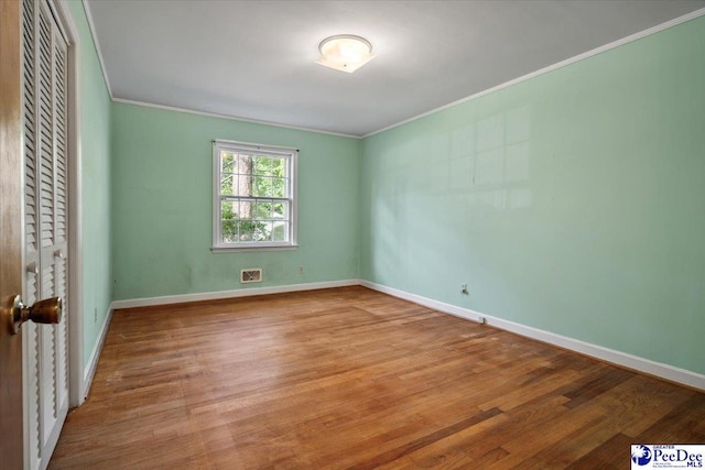1817 E Sandhurst Dr, Florence, SC 29505 - empty room featuring crown molding, wood finished floors, and baseboards