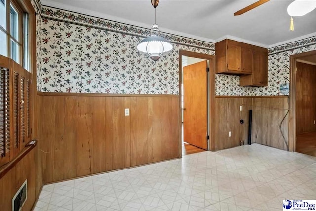 1817 E Sandhurst Dr, Florence, SC 29505 - kitchen with wallpapered walls, wainscoting, brown cabinetry, light floors, and ceiling fan
