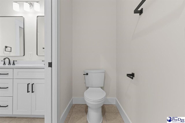 319 Railroad Ave, Florence, SC 29506 - bathroom with toilet, baseboards, vanity, and tile patterned flooring