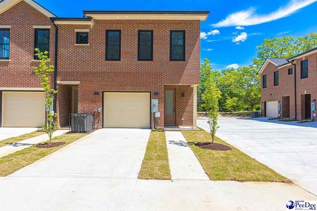 319 Railroad Ave, Florence, SC 29506 - view of property with brick siding, an attached garage, driveway, and central air condition unit
