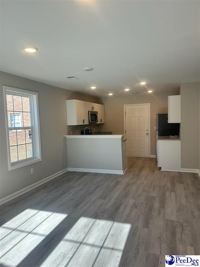 kitchen featuring hardwood / wood-style flooring, white cabinetry, and kitchen peninsula