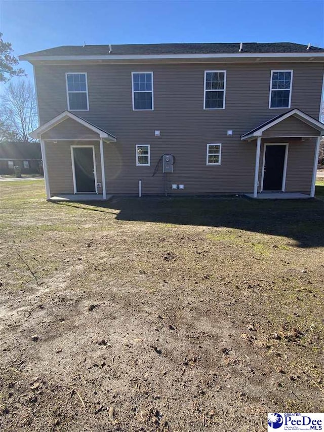 rear view of property with a lawn