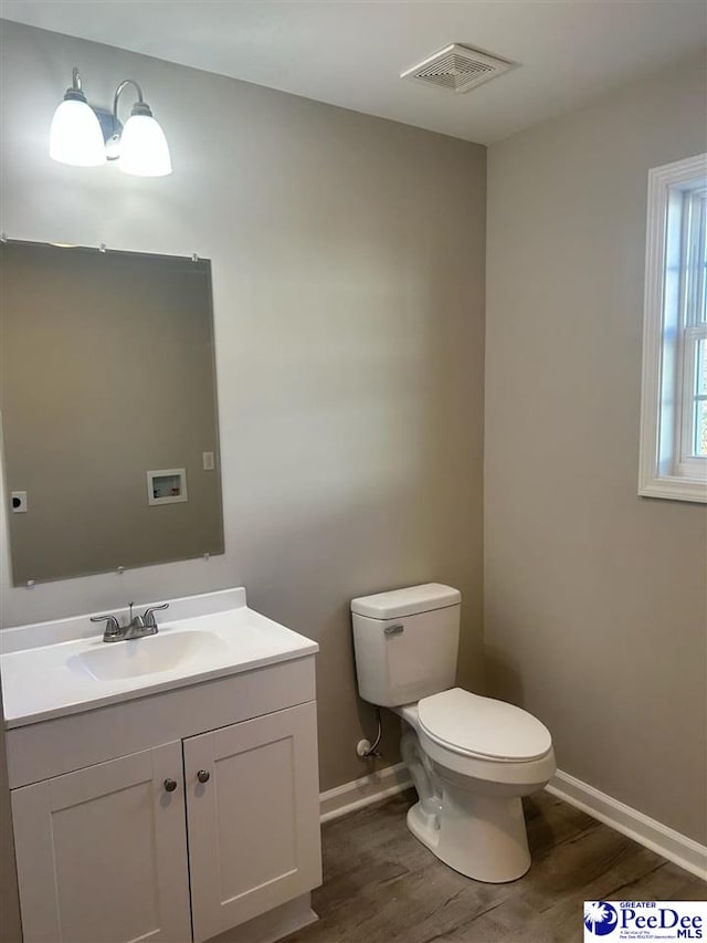 bathroom featuring wood-type flooring, vanity, and toilet