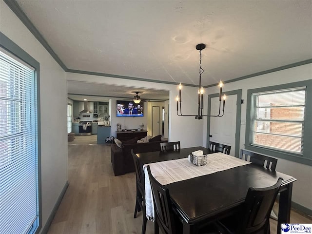 dining space with crown molding, ceiling fan, and hardwood / wood-style flooring