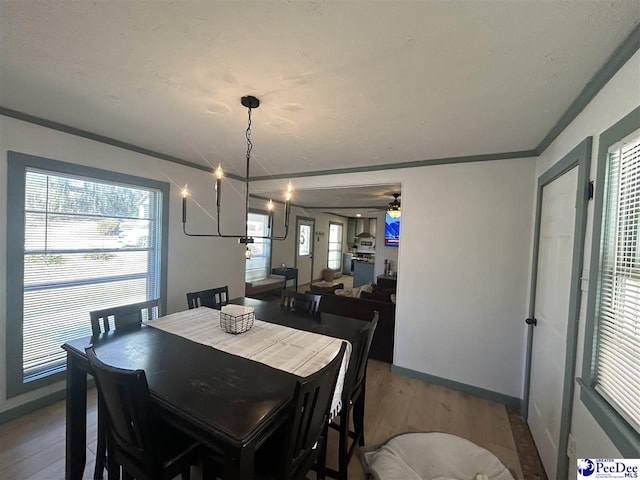 dining area featuring hardwood / wood-style flooring, crown molding, and ceiling fan