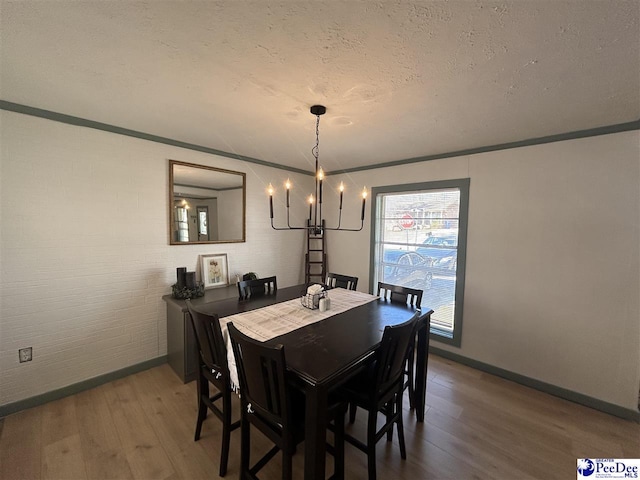 dining area featuring hardwood / wood-style flooring, a textured ceiling, and a notable chandelier