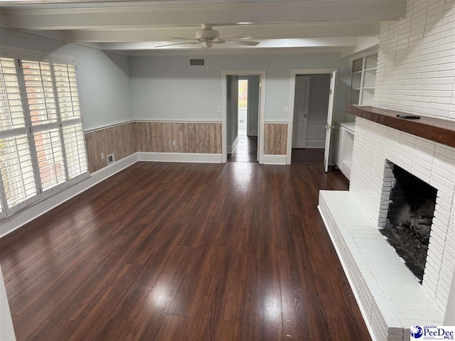 unfurnished living room with beam ceiling, dark hardwood / wood-style flooring, ceiling fan, and a fireplace