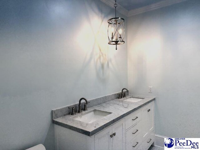 bathroom featuring vanity, a chandelier, and crown molding