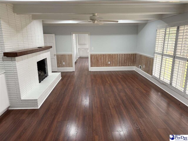 unfurnished living room with beam ceiling, ceiling fan, dark hardwood / wood-style floors, and a fireplace