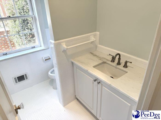 bathroom featuring vanity, tile patterned floors, toilet, and tile walls