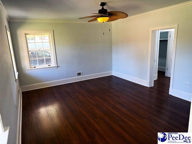 spare room with ceiling fan, ornamental molding, and dark hardwood / wood-style flooring