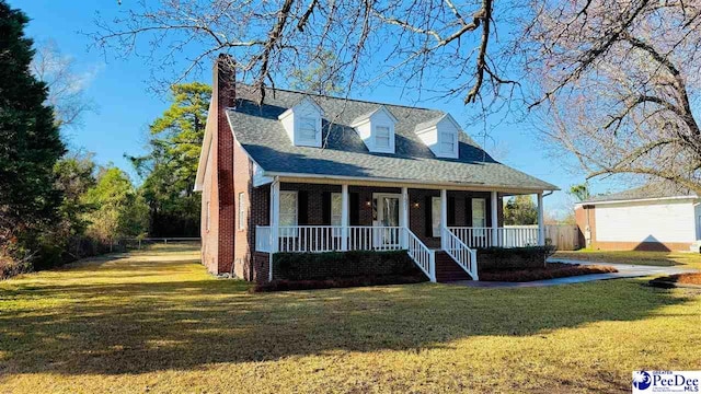 new england style home with covered porch and a front lawn