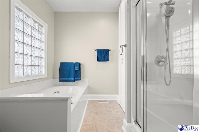 bathroom with visible vents, baseboards, a garden tub, and a stall shower