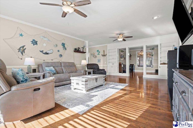 living room with built in features, wood finished floors, a ceiling fan, and ornamental molding