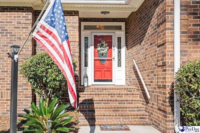 entrance to property featuring brick siding