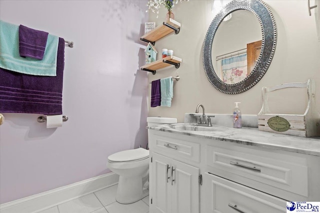 bathroom with baseboards, toilet, vanity, and tile patterned flooring