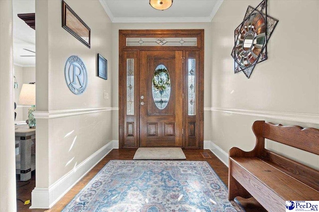 foyer entrance featuring baseboards, wood finished floors, and ornamental molding