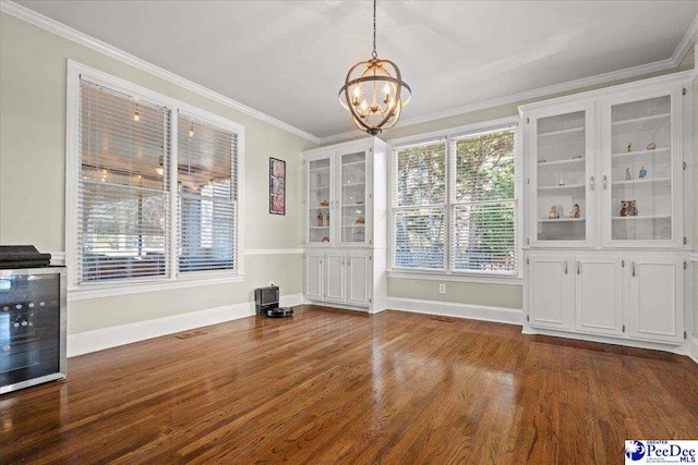 unfurnished dining area with a notable chandelier, baseboards, dark wood-style flooring, and ornamental molding