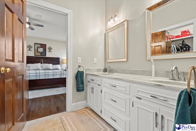 ensuite bathroom with a sink, ensuite bath, double vanity, and ceiling fan