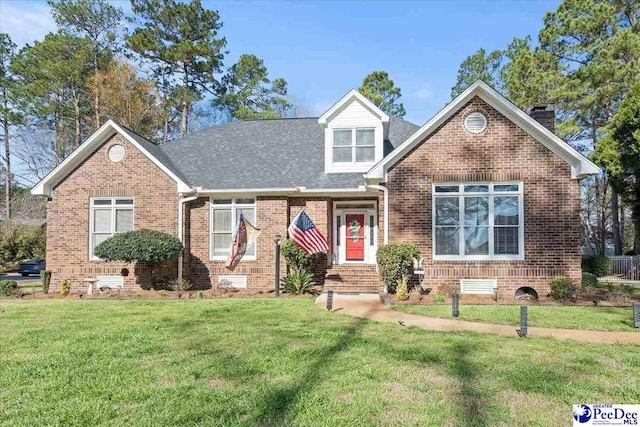 view of front of home featuring a front lawn, brick siding, roof with shingles, and crawl space