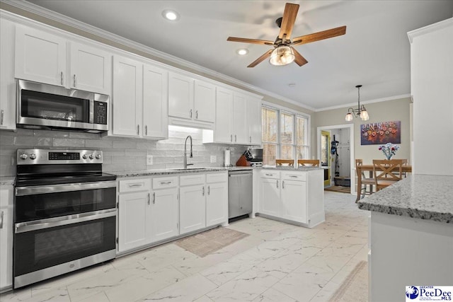 kitchen with marble finish floor, tasteful backsplash, white cabinetry, appliances with stainless steel finishes, and crown molding