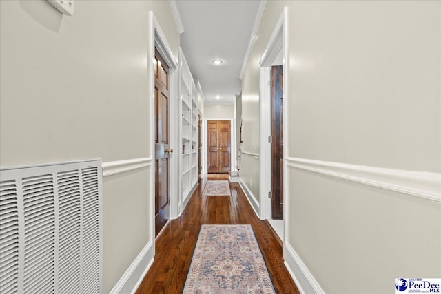 corridor featuring wood finished floors, visible vents, baseboards, recessed lighting, and crown molding