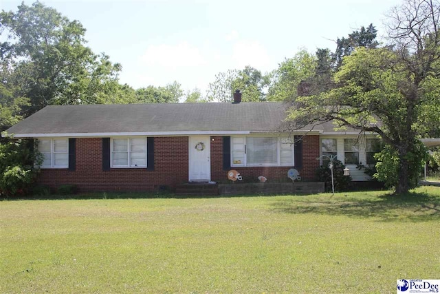 ranch-style home featuring brick siding, entry steps, and a front yard