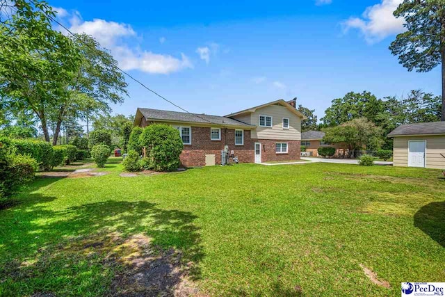908 Clarendon Ave, Florence, SC 29505 - back of house featuring brick siding and a lawn