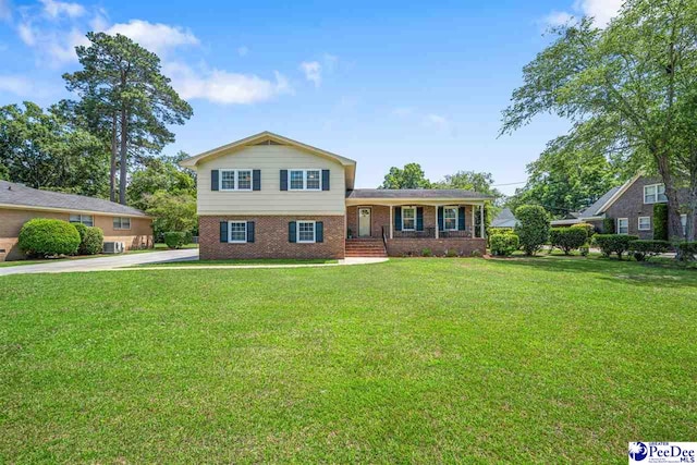 908 Clarendon Ave, Florence, SC 29505 - tri-level home featuring brick siding, a front lawn, and central AC unit
